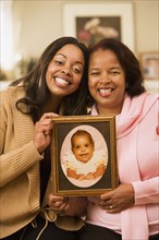 Mother and daughter displaying a baby picture
