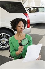 Woman reading the fine print with a magnifying glass