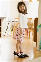 Young girl wearing mother's shoes