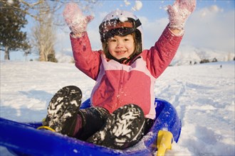 Young girl on sled in the snow