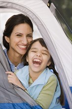 Hispanic mother and daughter laughing in tent