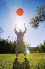 Boy throwing ball in bright sunlight