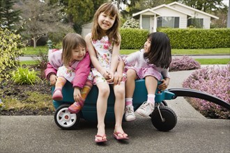 Three young Asian girls in wagon