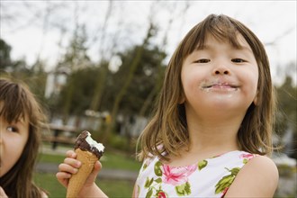 Young Asian girl eating ice cream cone