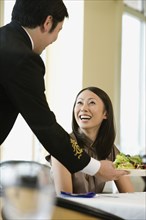 Asian woman being served in restaurant