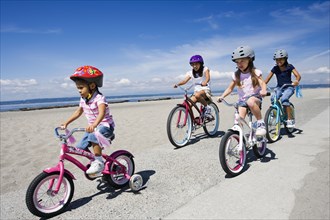 Young girls riding bicycles at beach