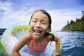 Asian girl swimming with inner tube