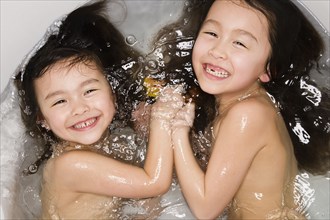 Asian sisters in bath tub