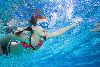 Underwater shot of Asian girl swimming