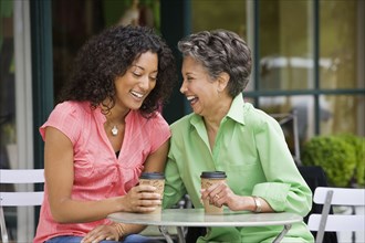 African American mother and adult daughter laughing