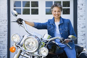 Senior African American woman sitting on motorcycle