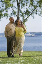 African American couple waking next to water