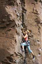 Asian woman rock climbing