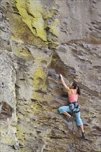 Asian woman rock climbing
