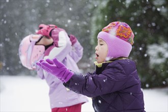 Asian sisters playing in snow