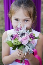 Asian flower girl holding floral bouquet