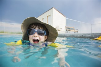Mixed race girl wearing sunglasses in swimming pool