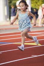 Asian girl running on race track
