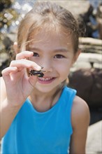 Asian girl holding tiny crab