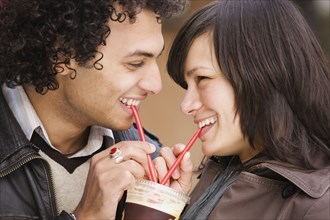 Couple drinking from one cup