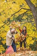 Hispanic couple playing with autumn leaves