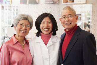 Korean optician standing with customers