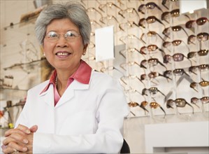 Chinese optician standing in store