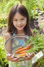 Mixed race girl holding carrots