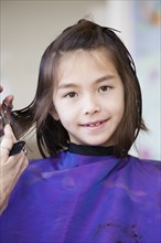 Mixed race girl getting her hair cut