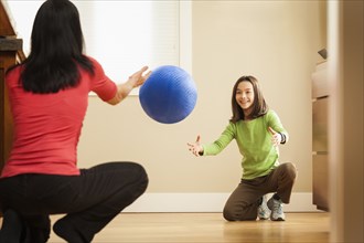 Mother and daughter playing with ball