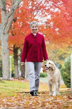 Mixed race woman walking dog