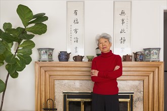 Chinese woman standing at fireplace