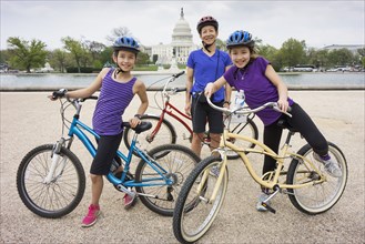 Mother and daughters riding bicycles by Capitol Building