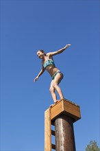 Mixed race girl jumping off platform