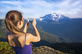 Mixed race girl photographing mountains