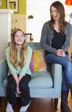 Caucasian mother and daughter smiling in living room