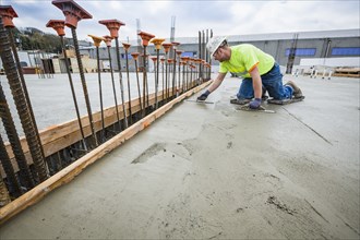 Worker finishing concrete at construction site