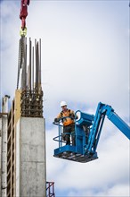 Caucasian worker standing on boom lift on site