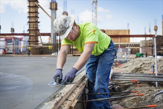 Construction worker finishing concrete at construction site