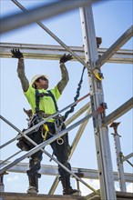 Caucasian worker on scaffolding on construction site