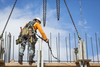 Caucasian worker holding chain at construction site