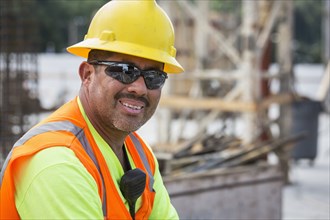 Hispanic worker smiling at construction site