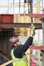Caucasian worker holding hook at construction site