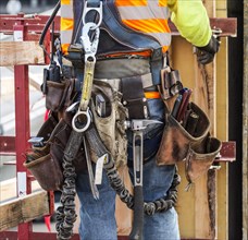 Hispanic worker wearing tool belt at construction site