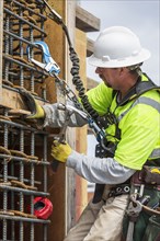 Caucasian worker examining wall at construction site