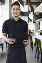 Asian waiter standing in restaurant
