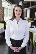 Caucasian waitress smiling in restaurant