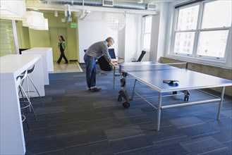 Businessman standing at table tennis table in office