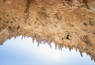 Caucasian climber scaling rock wall