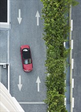 Aerial view of car driving on street with arrows
